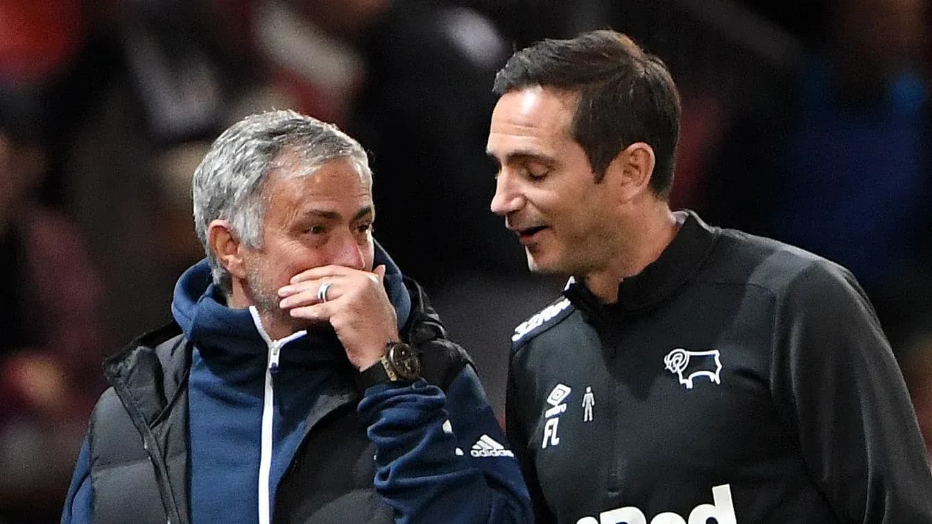 Two football managers talking on the sidelines