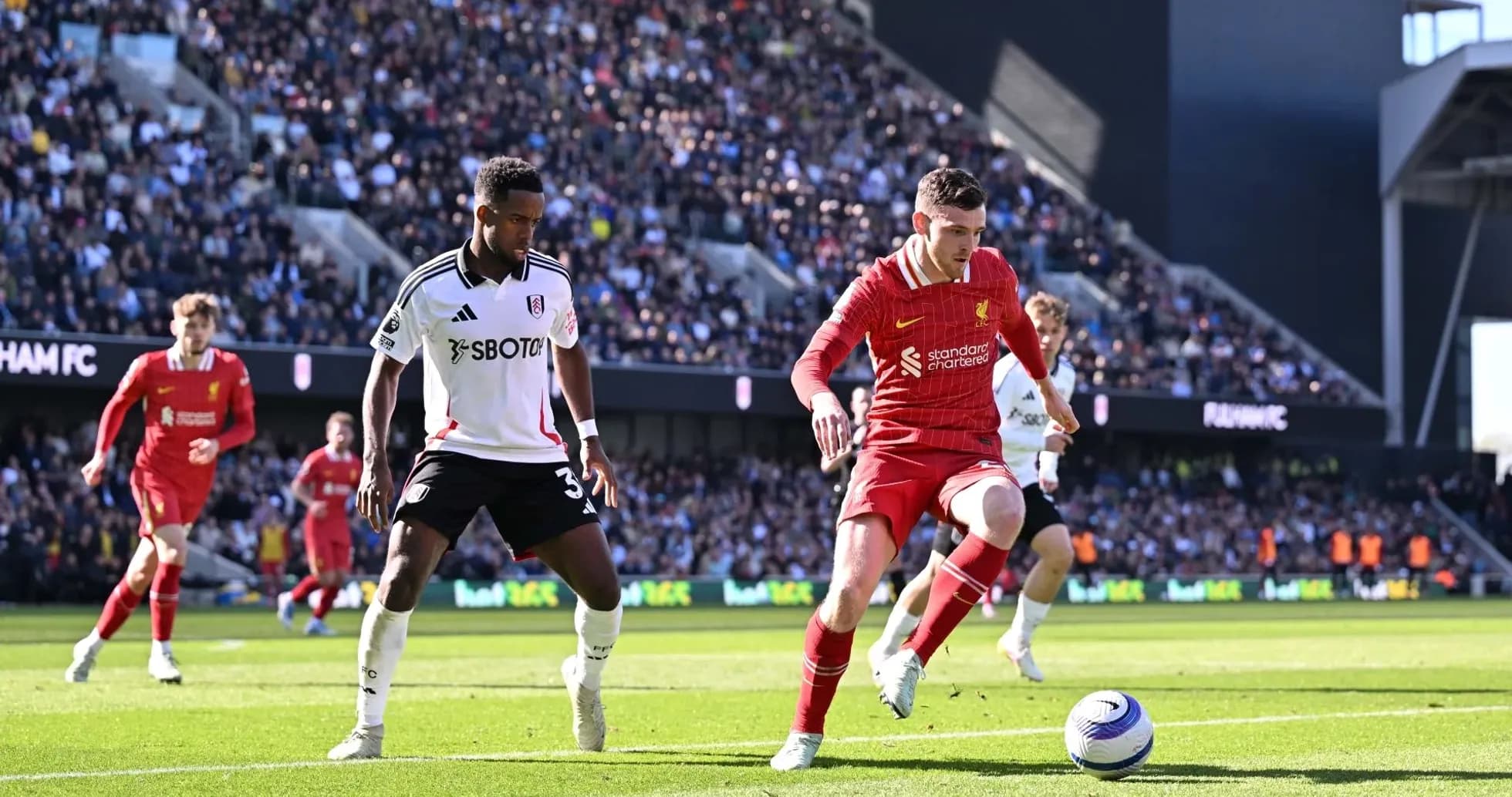 Liverpool player dribbling against Fulham defenders