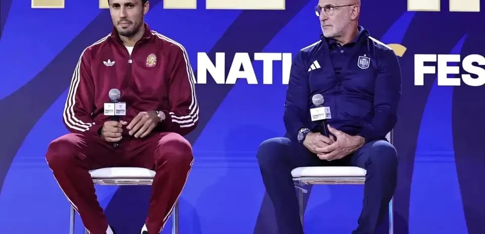 Two coaches seated at press conference with microphones