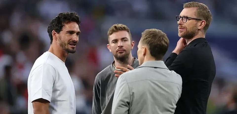 Four men conversing on the sidelines of a match