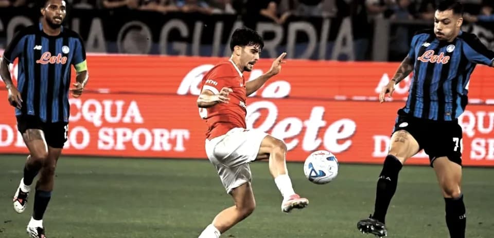 Player kicking ball during match with defenders nearby