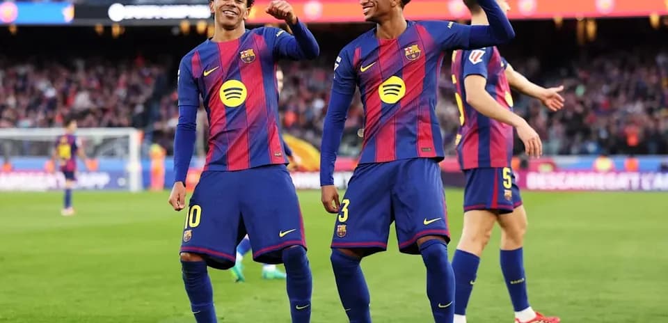 Two FC Barcelona players celebrating on the field
