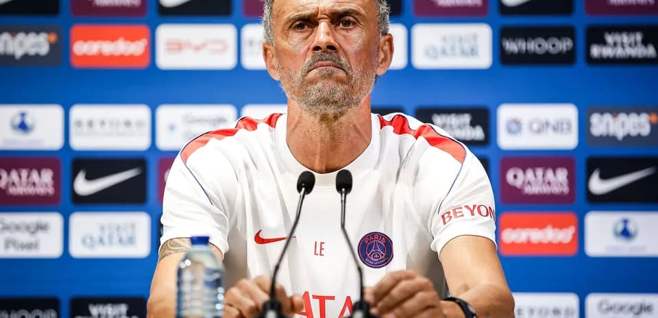 Manager at press conference with team branding backdrop