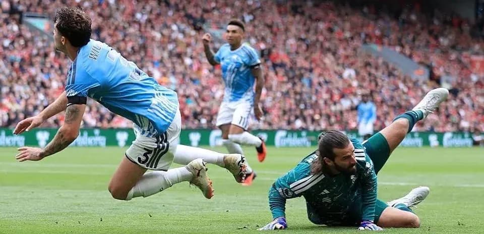 Goalkeeper making a save as player falls