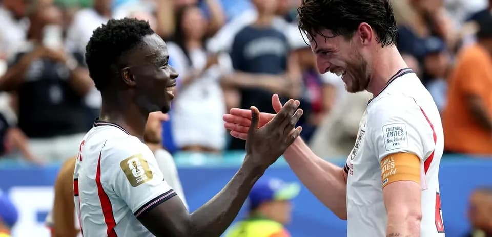 Two players celebrating and shaking hands on field