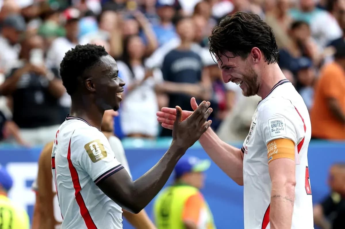 Two players celebrating and shaking hands on field