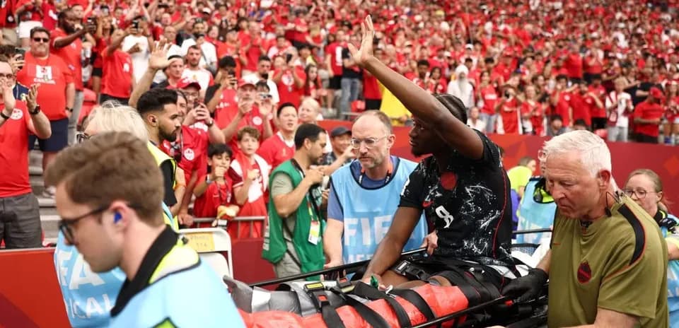 Player being carried on stretcher amid cheering crowd