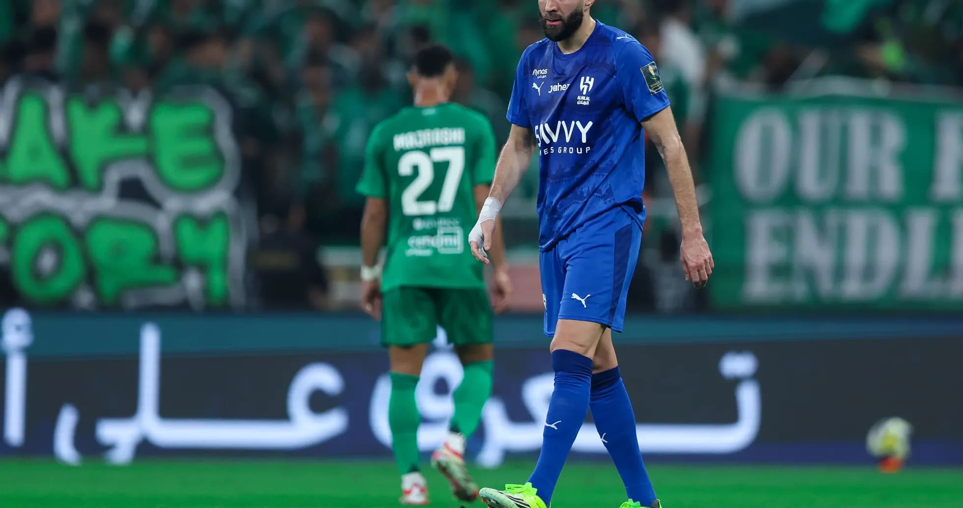 Player in blue jersey walking on field during match