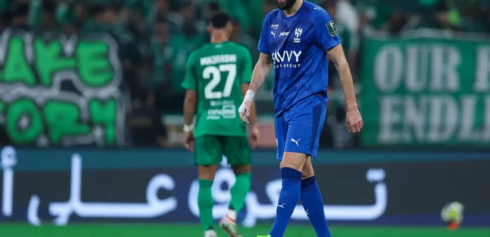 Player in blue jersey walking on field during match