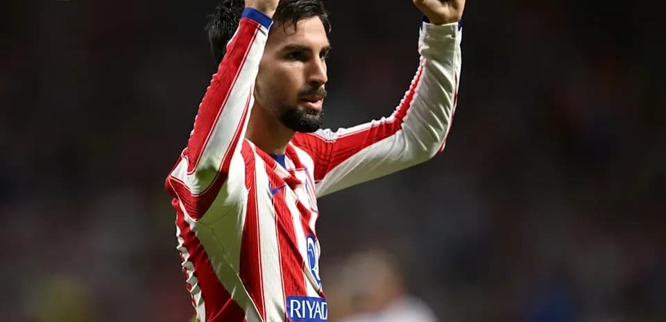 Player celebrating with raised fists in team jersey