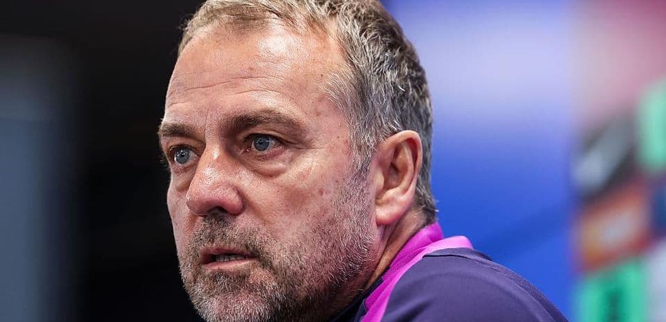 Coach speaking at press conference with serious expression