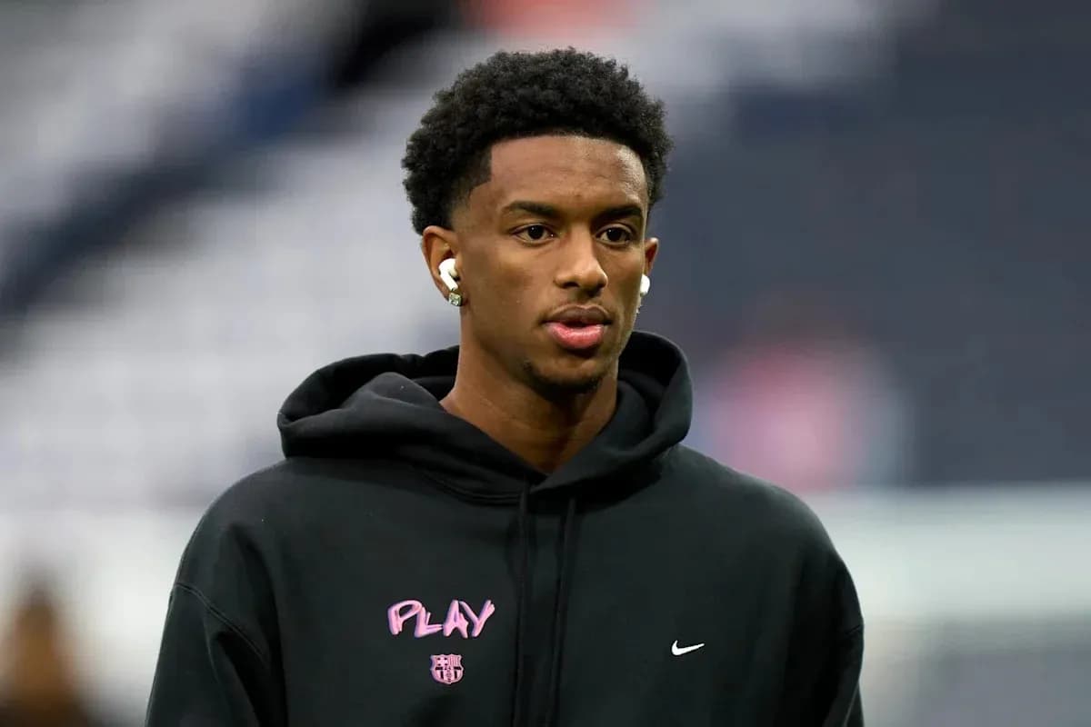 Player wearing earbuds and black hoodie before game