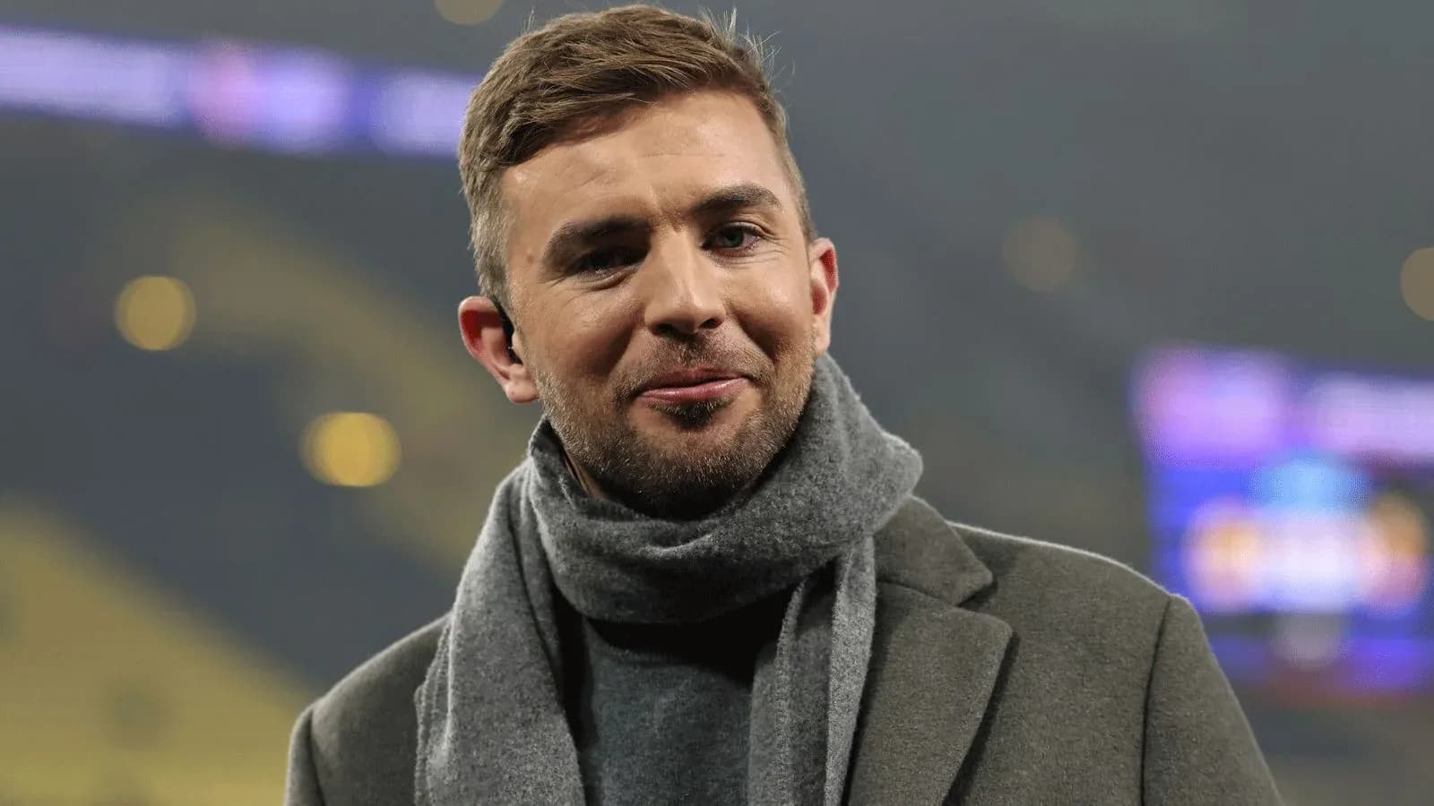 Person wearing a gray scarf and coat