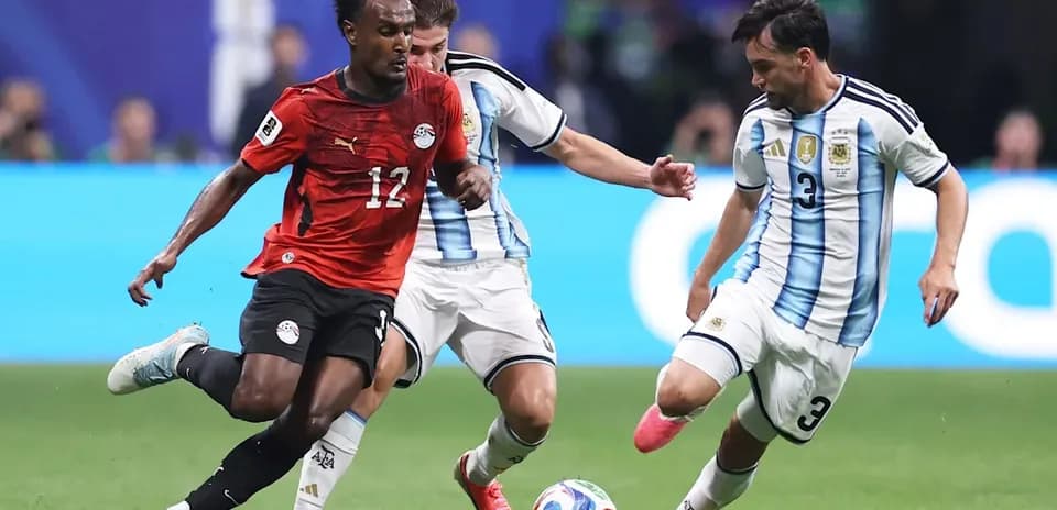 Egyptian player dribbling past Argentinian defenders