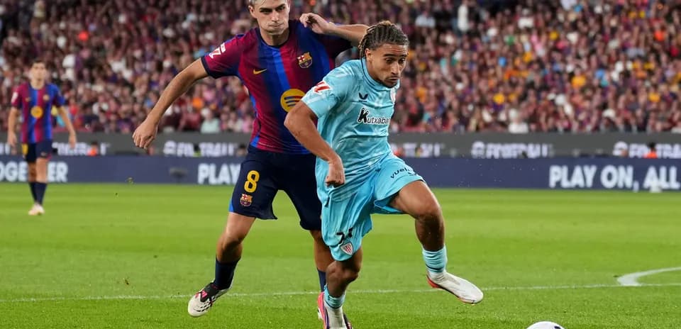 Player from Barcelona tackles opponent during match