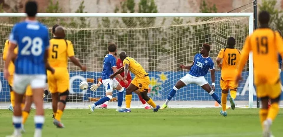 Players competing near the goal during football match