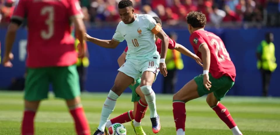 Player from France dribbling against Moroccan defenders