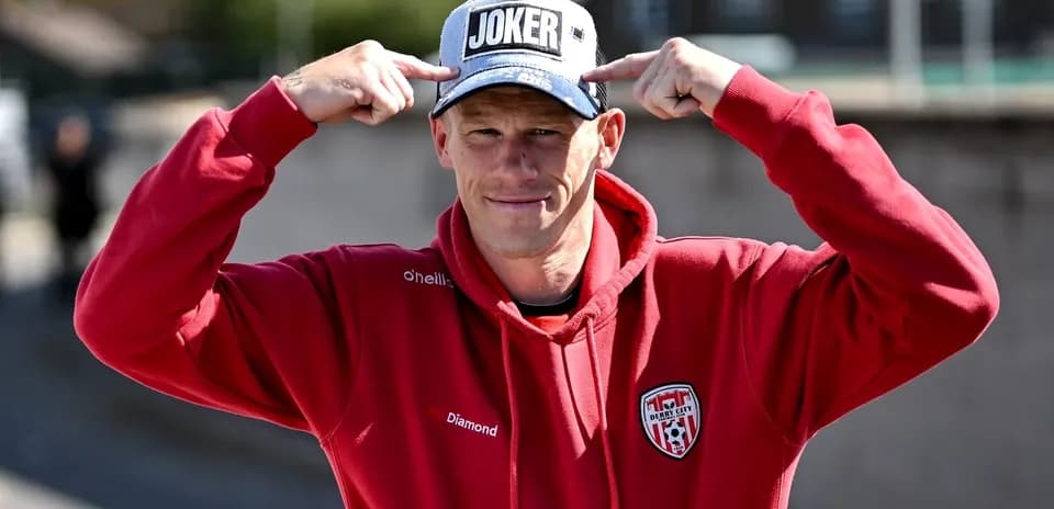Person wearing a 'JOKER' cap and red hoodie