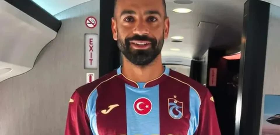 Player wearing Trabzonspor jersey inside an airplane