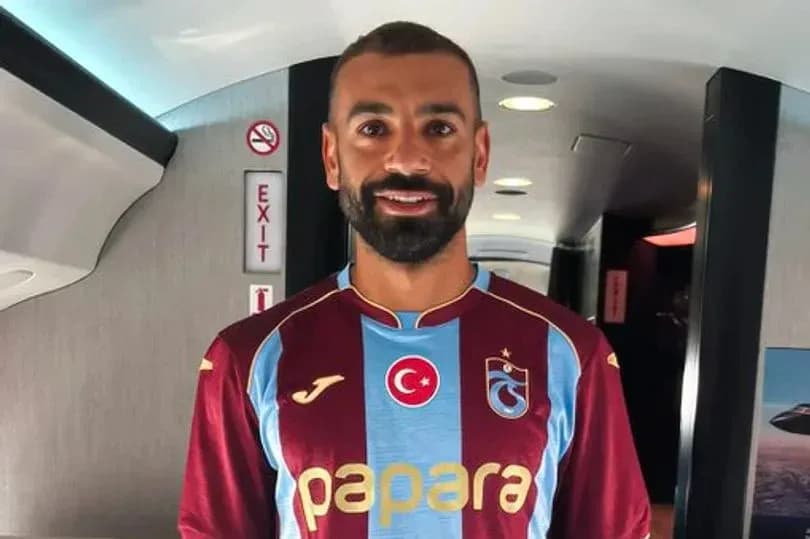 Player wearing Trabzonspor jersey inside an airplane