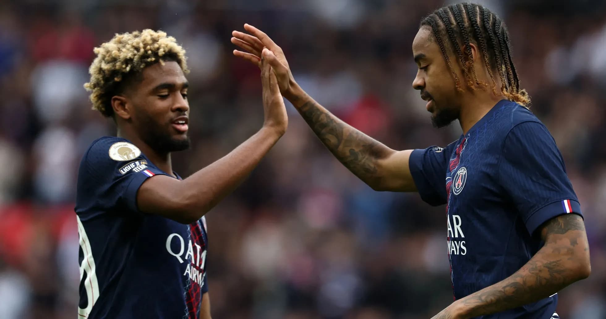 Two PSG players celebrating during a match