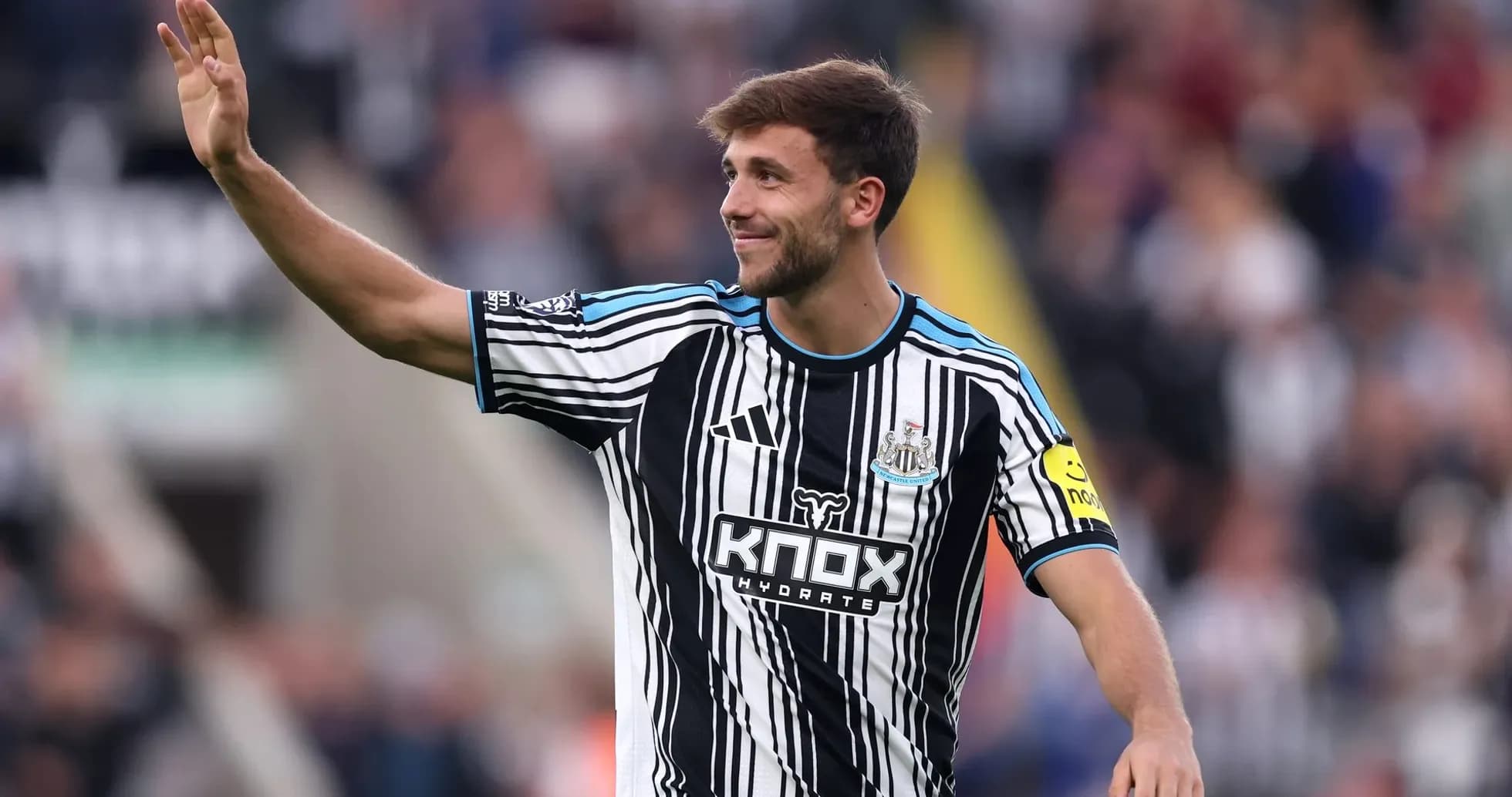 Player waving to fans in Newcastle home jersey