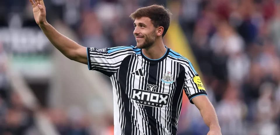 Player waving to fans in Newcastle home jersey