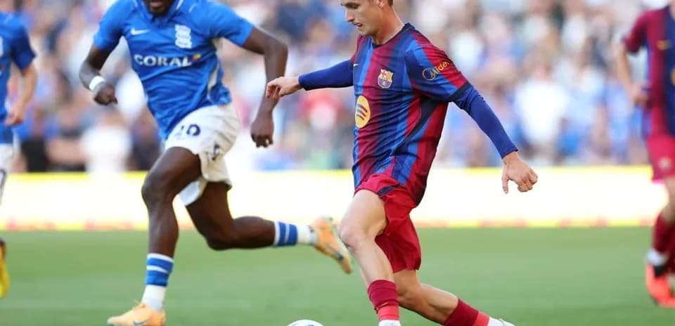 Barcelona player dribbling past Birmingham opponent