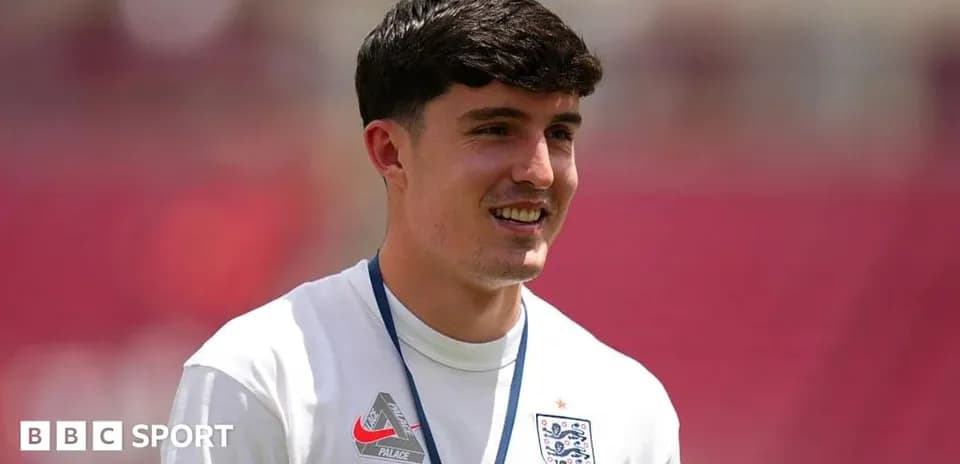 Player in England training kit smiling on pitch