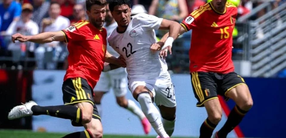Egyptian player evading two Belgian defenders during match