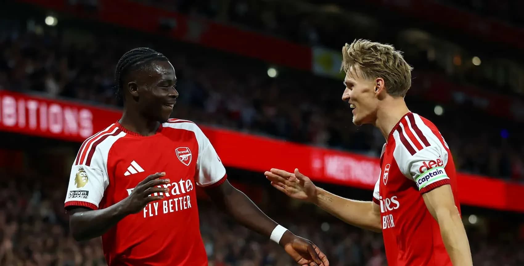 Two Arsenal players celebrating a goal together