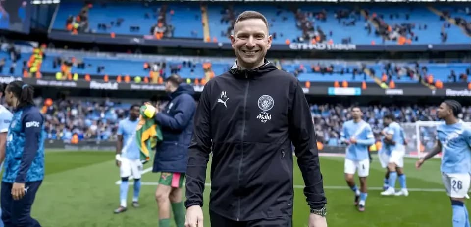 Coach smiling as players leave the pitch