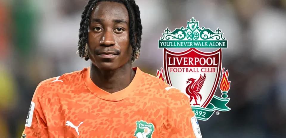 Goalkeeper wearing orange jersey with Liverpool logo