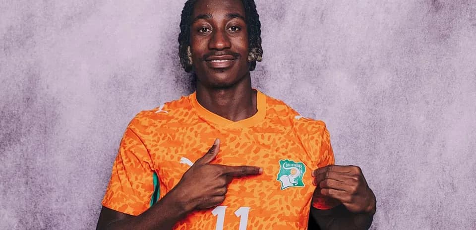 Player pointing at Cote d'Ivoire jersey emblem