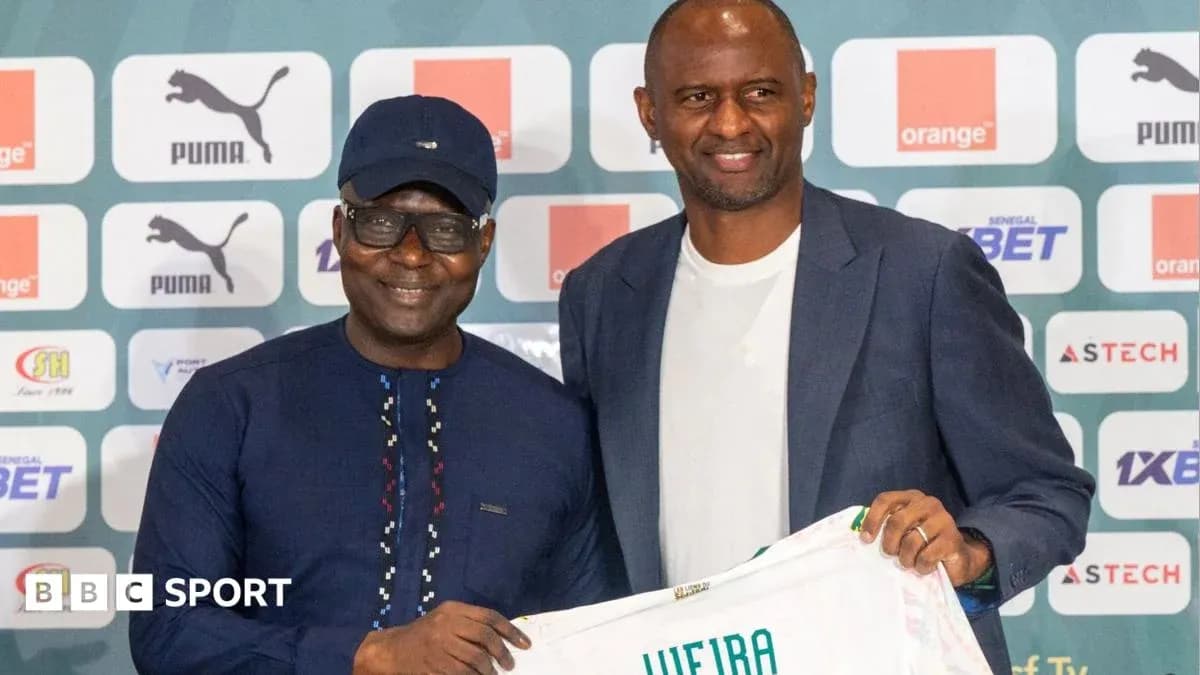 Two men holding a football jersey at press event