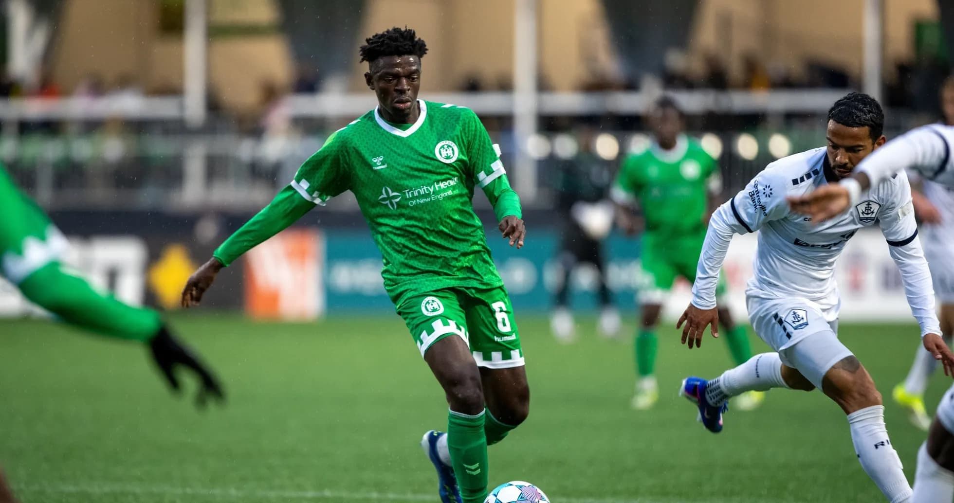 Player in green jersey dribbling the ball