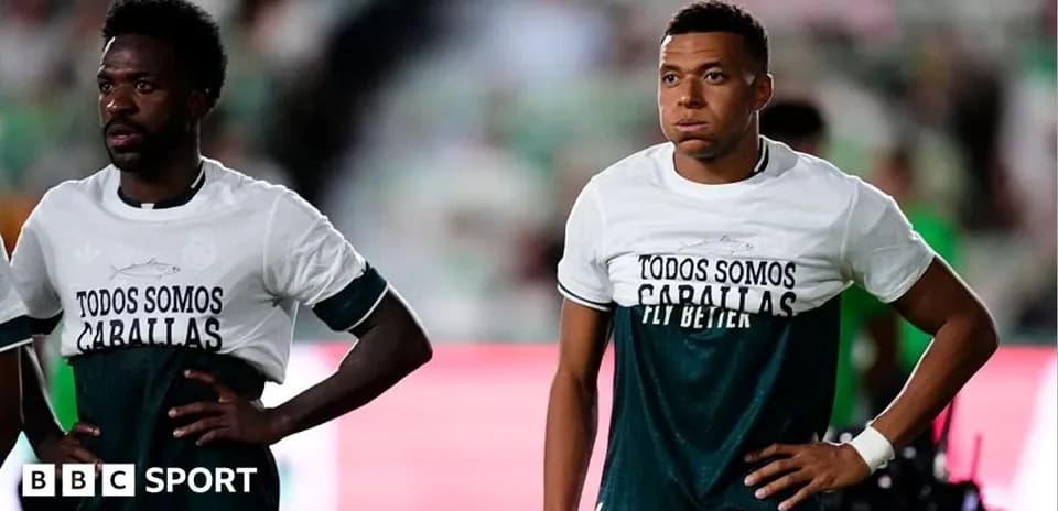 Two players wearing matching warm-up shirts on field