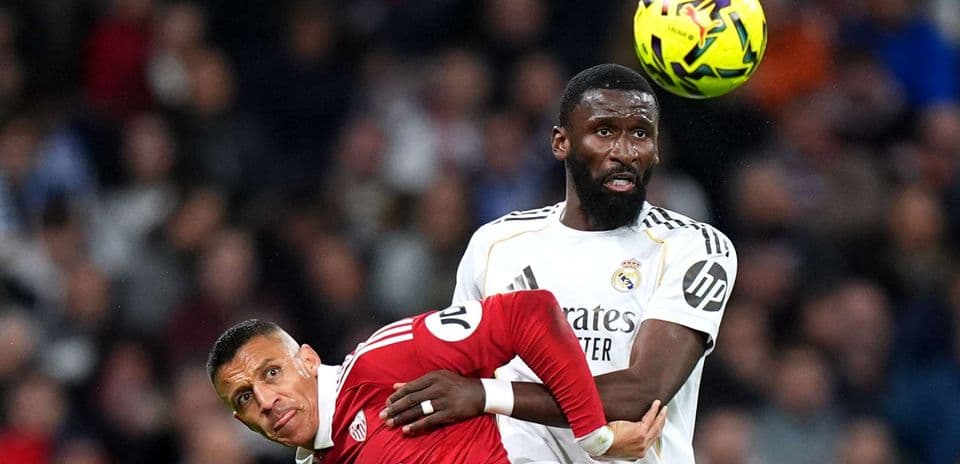 Sevilla player challenged by Real Madrid defender