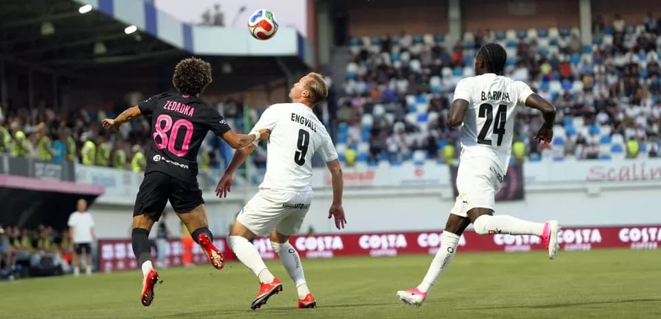 Players competing for the ball in UEFA match