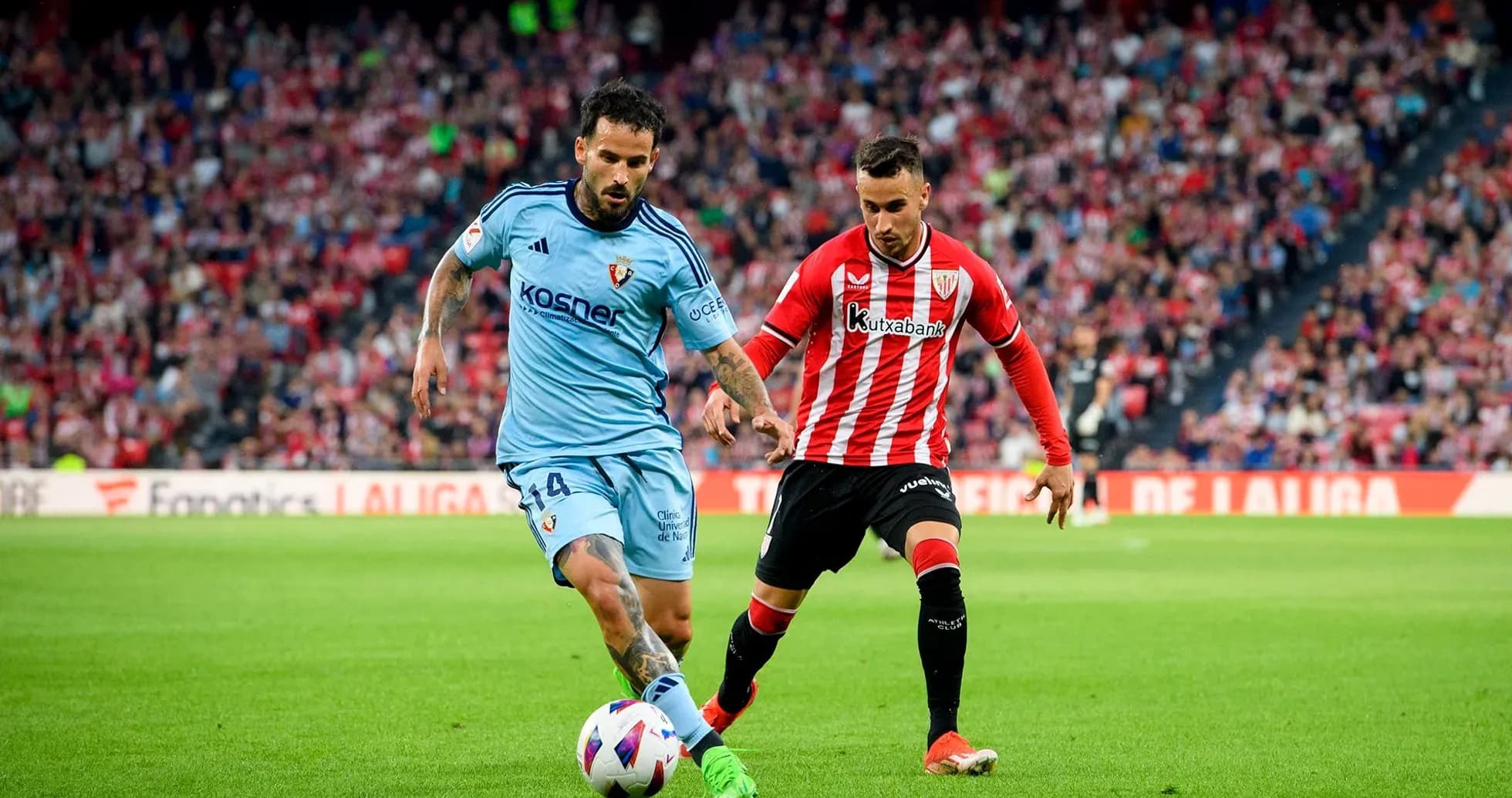 Athletic Club player challenging Osasuna opponent