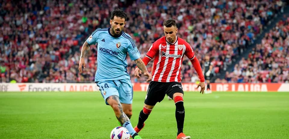 Athletic Club player challenging Osasuna opponent