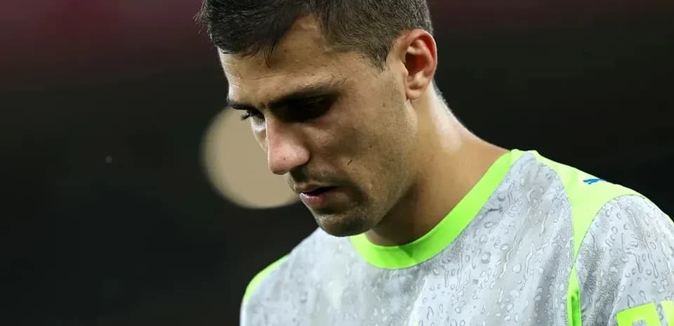 Player in training gear looking down on field