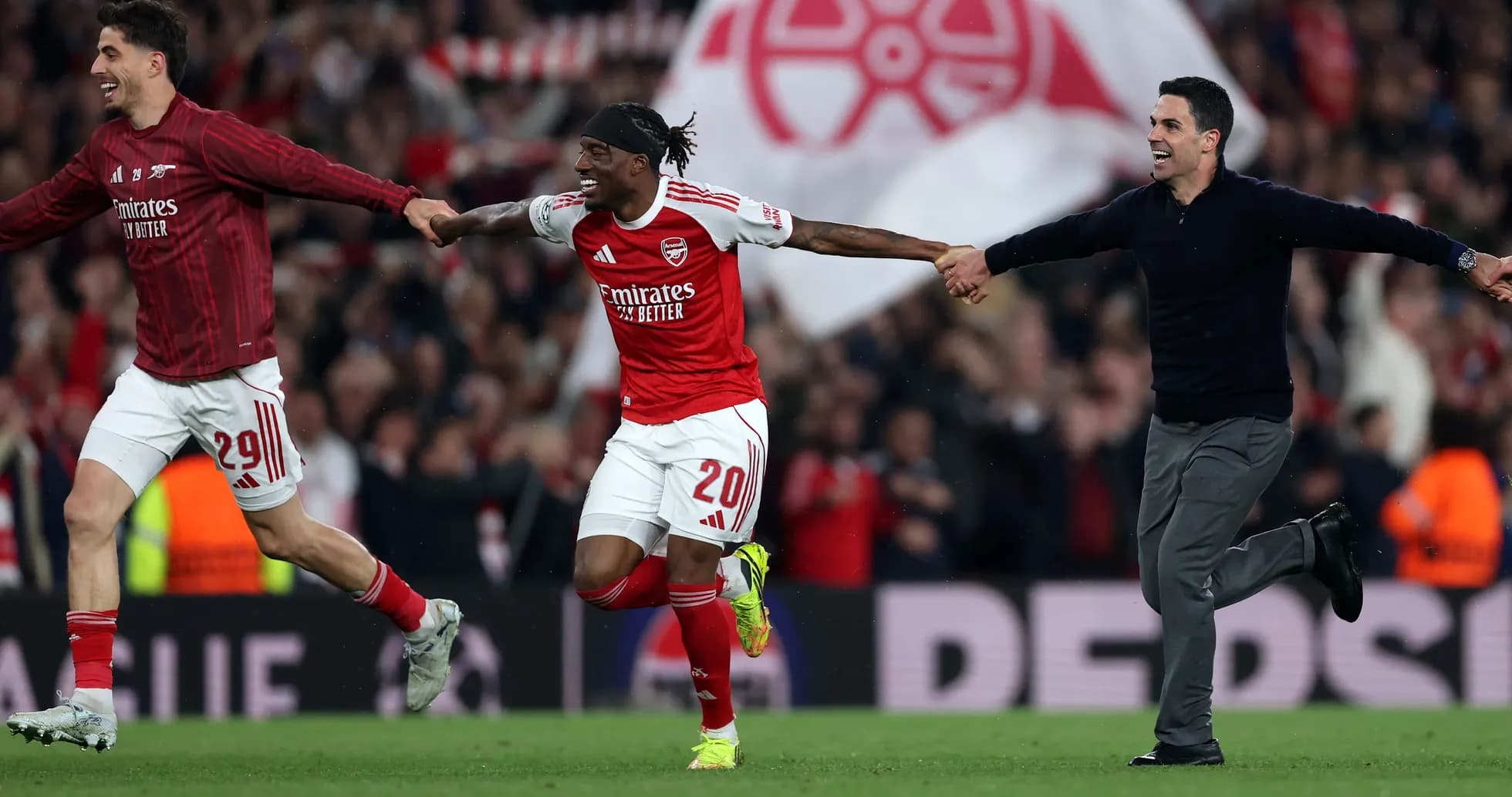 Arsenal players celebrating on the pitch after victory