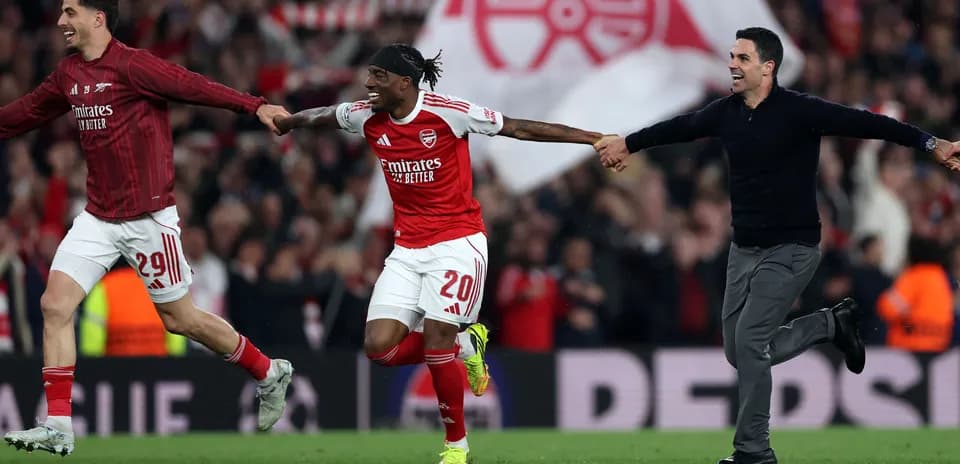 Arsenal players celebrating on the pitch after victory