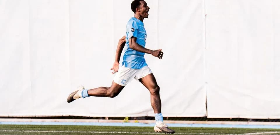 Player celebrating a goal while running on field
