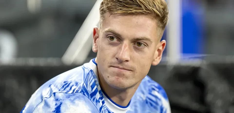 Player sitting on bench wearing blue jersey