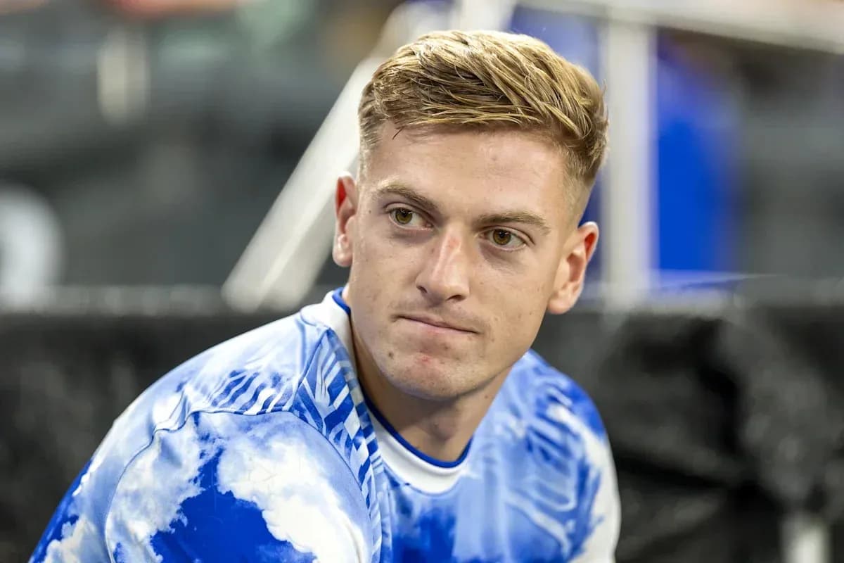Player sitting on bench wearing blue jersey