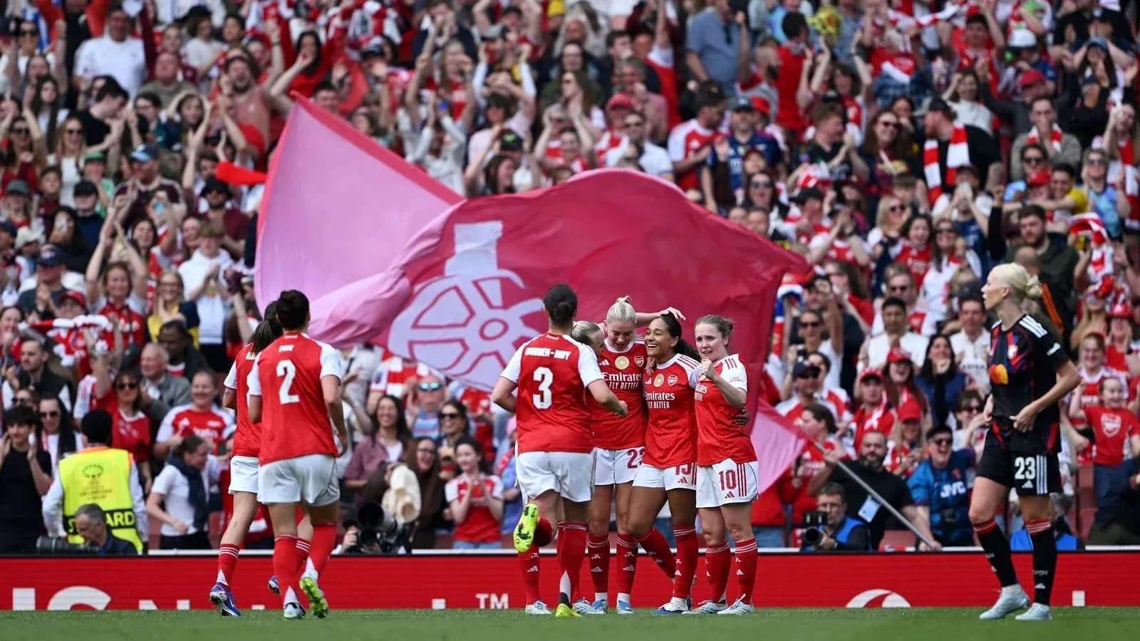 Arsenal players celebrating a goal with fans in background