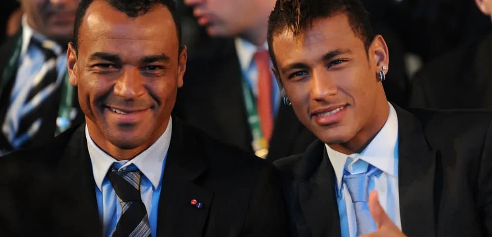 Two men smiling and sitting together at event