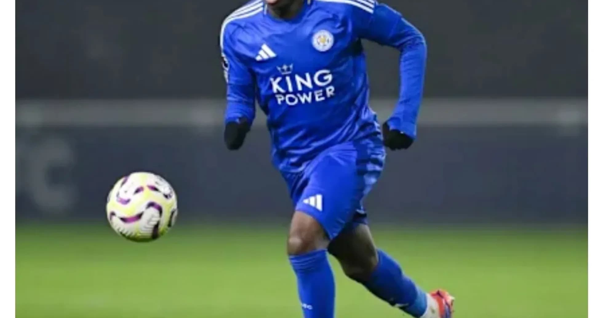 Player in blue kit dribbling a soccer ball